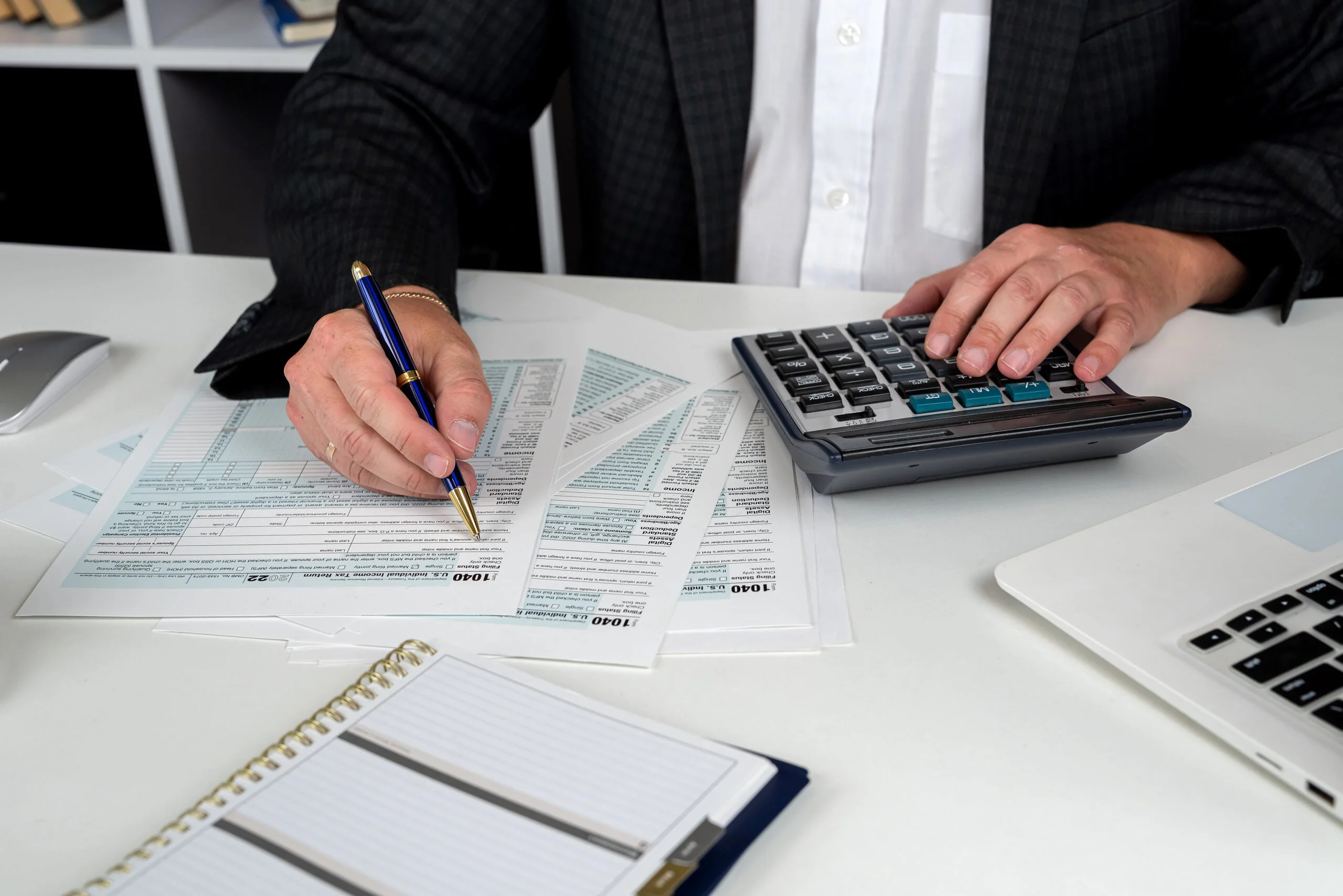 close up of male hand filling US tax form Accountant working with 1040 form