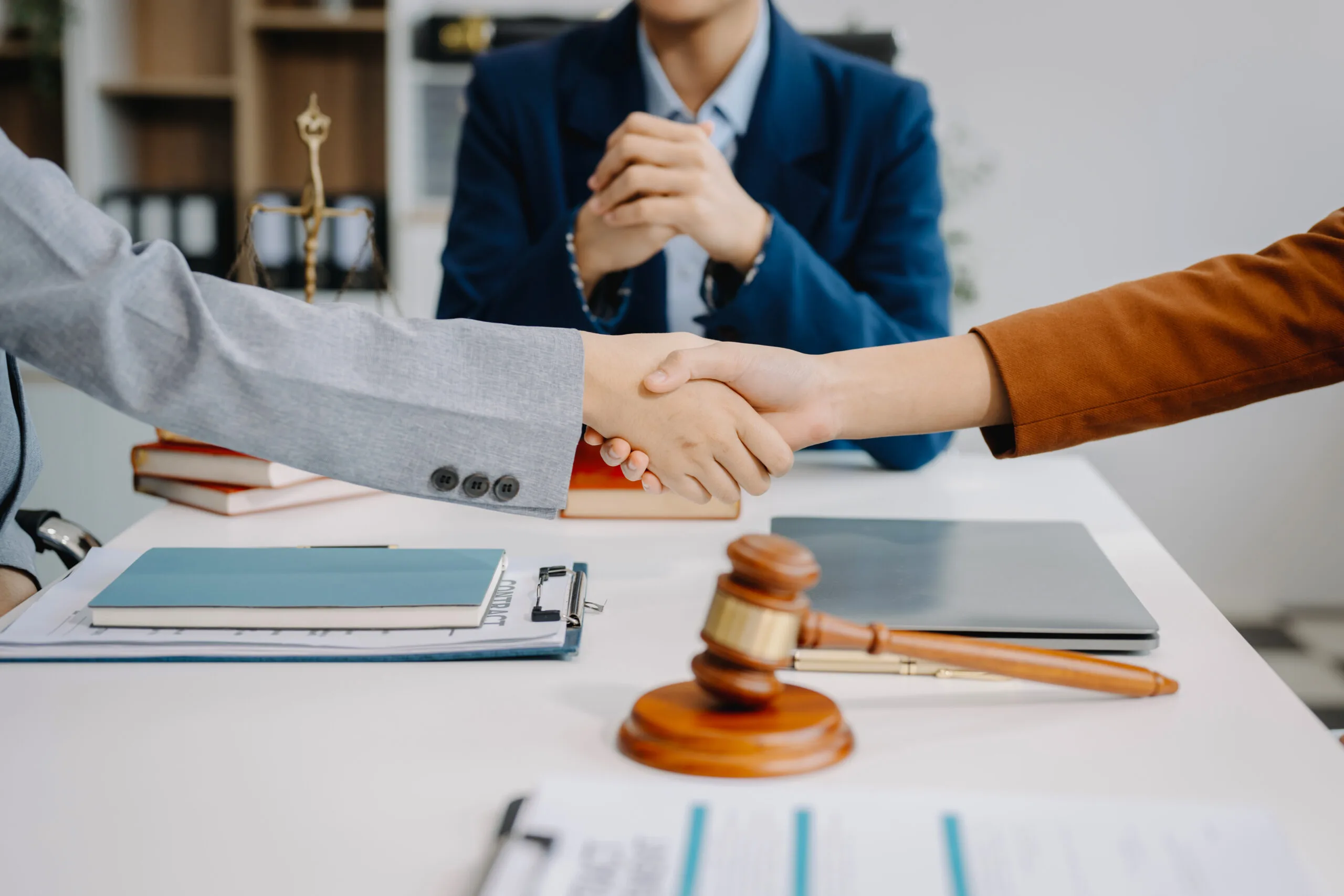 Judge and client shaking hands and lawyers discussing contract papers after adviced at courtroom lawyer service conceptxA